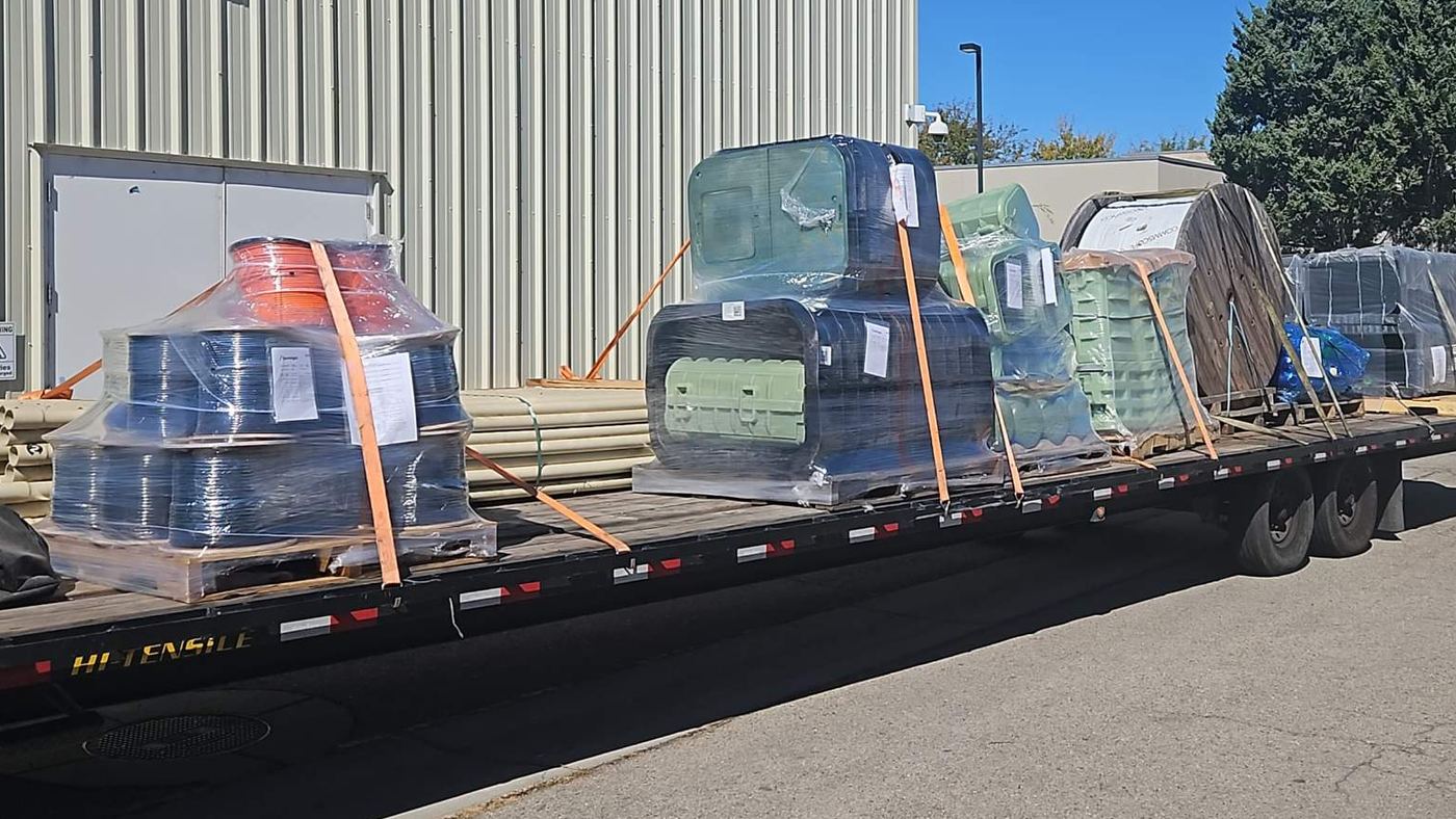 Palletized freight wrapped and strapped on an open flatbed deck